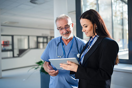 A healthcare administrator talking with a doctor